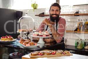 Waiter posing with cakes