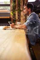 Man drinking coffee and using tablet