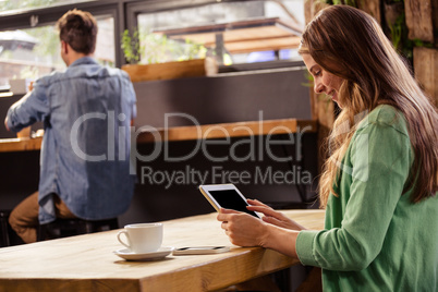 Woman using a tablet sitting and smiling