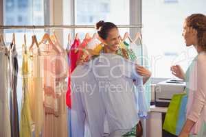 Woman showing shirt to her friend at shopping mall