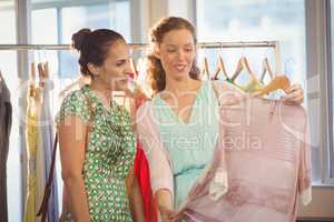 Woman showing shirt to her friend at shopping mall