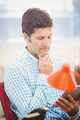 Thoughtful businessman using his tablet