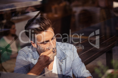 Handsome hipster man eating while sitting