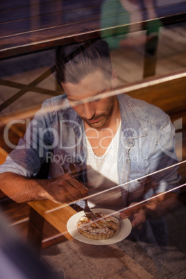 Facing view of hipster man eating pastries