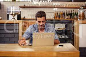 Happy hipster man using tablet and drinking coffee