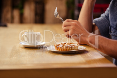 Cropped image of hipster man eating and drinking coffee