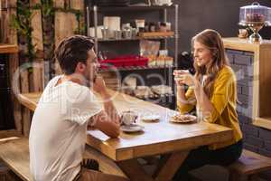 Two smiling hipsters drinking coffee