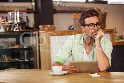 Bored hipster man using tablet computer