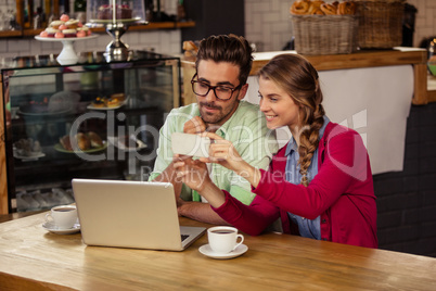 Two hipsters friends looking at smartphone