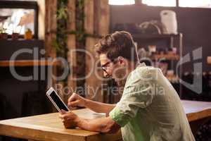 Profile view of hipster man using tablet