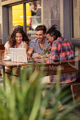 Smiling friends drinking coffee and laughing