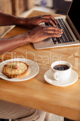Cropped image of casual man using laptop