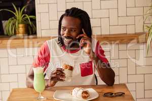 Portrait of hipster man on the phone while eating