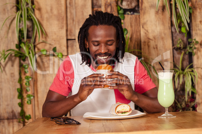 Facing view of hipster man eating sandwich