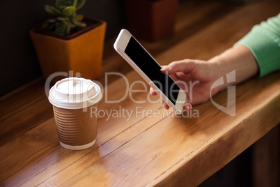 Focus on hipster woman using smartphone with drink