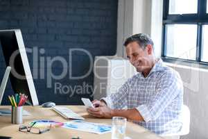 Businessman smiling and using a mobile phone