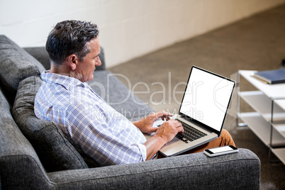 Profile view of businessman working with his laptop