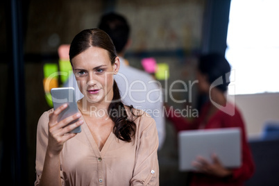 Focus on foreground of woman looking her mobile phone