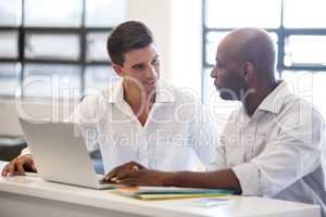 Coworkers talking front of laptop