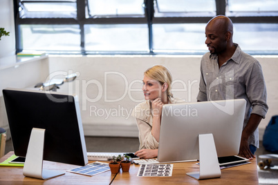 Coworkers looking a computer