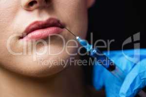 Woman receiving botox injection on her lips