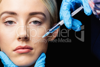 Woman receiving botox injection on her lips