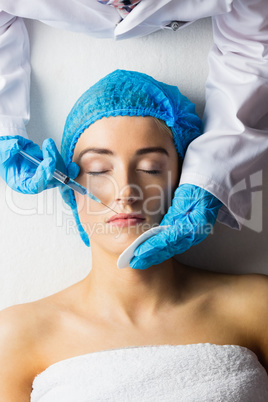 Woman receiving botox injection on her lips