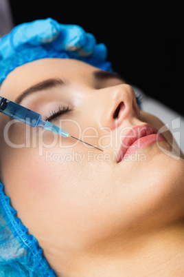 Woman receiving botox injection on her lips