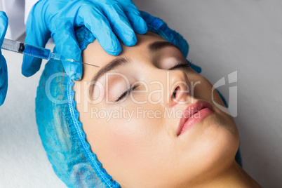 Woman receiving botox injection on her forehead