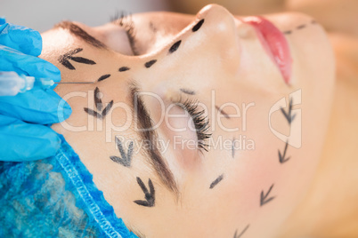 Woman receiving botox injection on her forehead