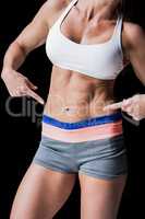 Female athlete pointing her abs