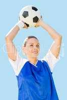 Composite image of woman soccer player holding a ball