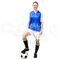 Woman soccer player smiling and posing with a ball