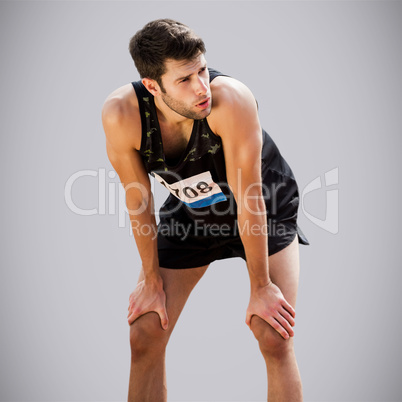 Composite image of athletic man resting with hands on knees