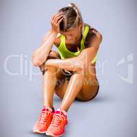 Composite image of sporty woman sitting down and feeling disappo