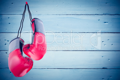 Composite image of boxing gloves attached to white background