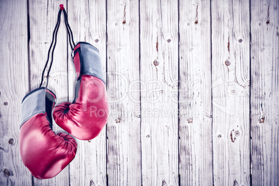 Composite image of boxing gloves attached to white background