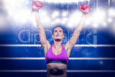 Composite image of winner female boxer with arms raised
