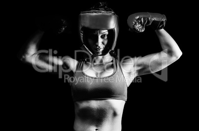Composite image of portrait of confident female fighter flexing