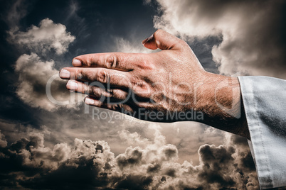 Composite image of karate player making hand gesture on black ba