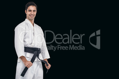 Composite image of fighter tightening karate belt