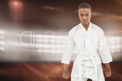 Composite image of front view of karate fighter meditating