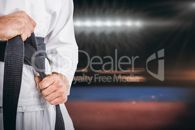 Composite image of fighter tightening karate belt