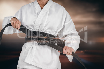 Composite image of female athlete tightening her judo belt
