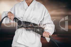 Composite image of female athlete tightening her judo belt