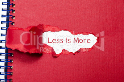 The word less is more appearing behind torn paper.