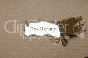 The word tax refund appearing behind torn paper.