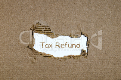 The word tax refund appearing behind torn paper.