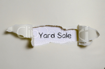 The word yard sale appearing behind torn paper.