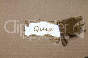 The word quiz appearing behind torn paper.